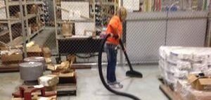 Water Damage Restoration Technician Cleaning After Warehouse Flooding